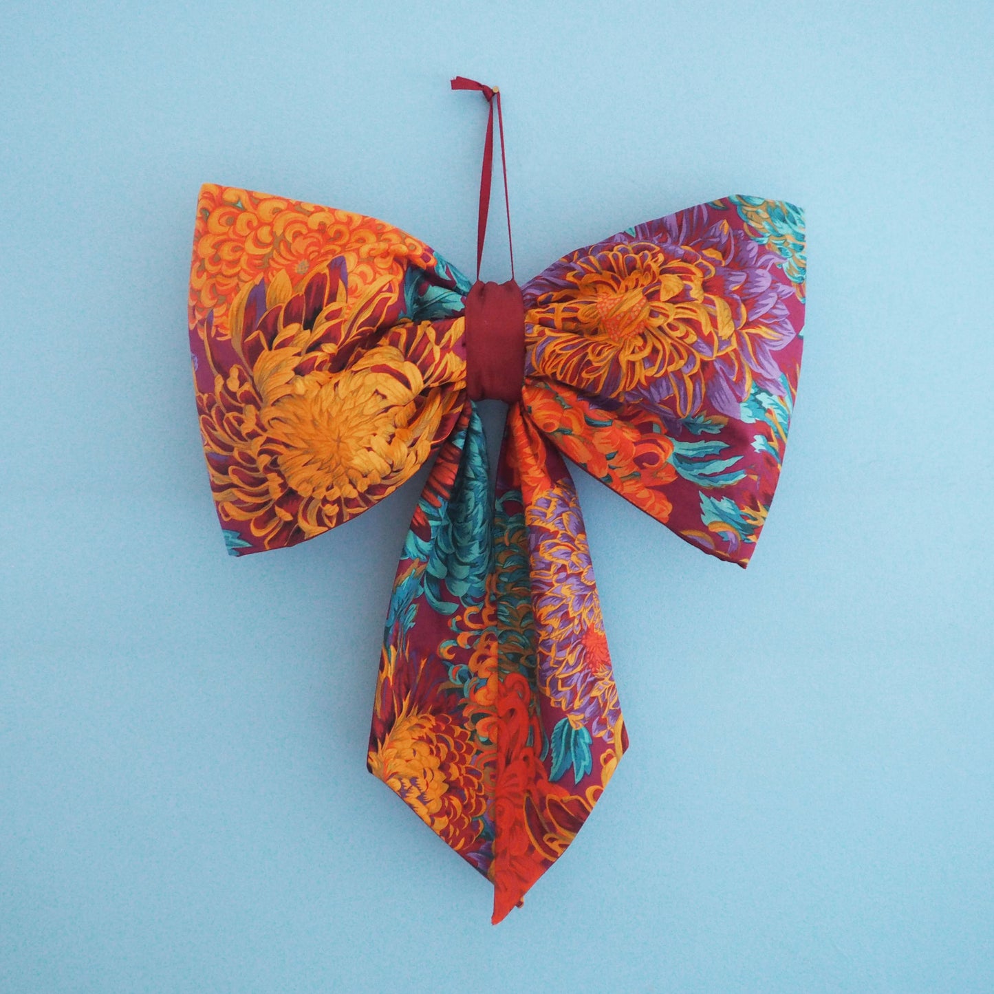 Handmade large padded decorative hanging bow - orange/purple floral