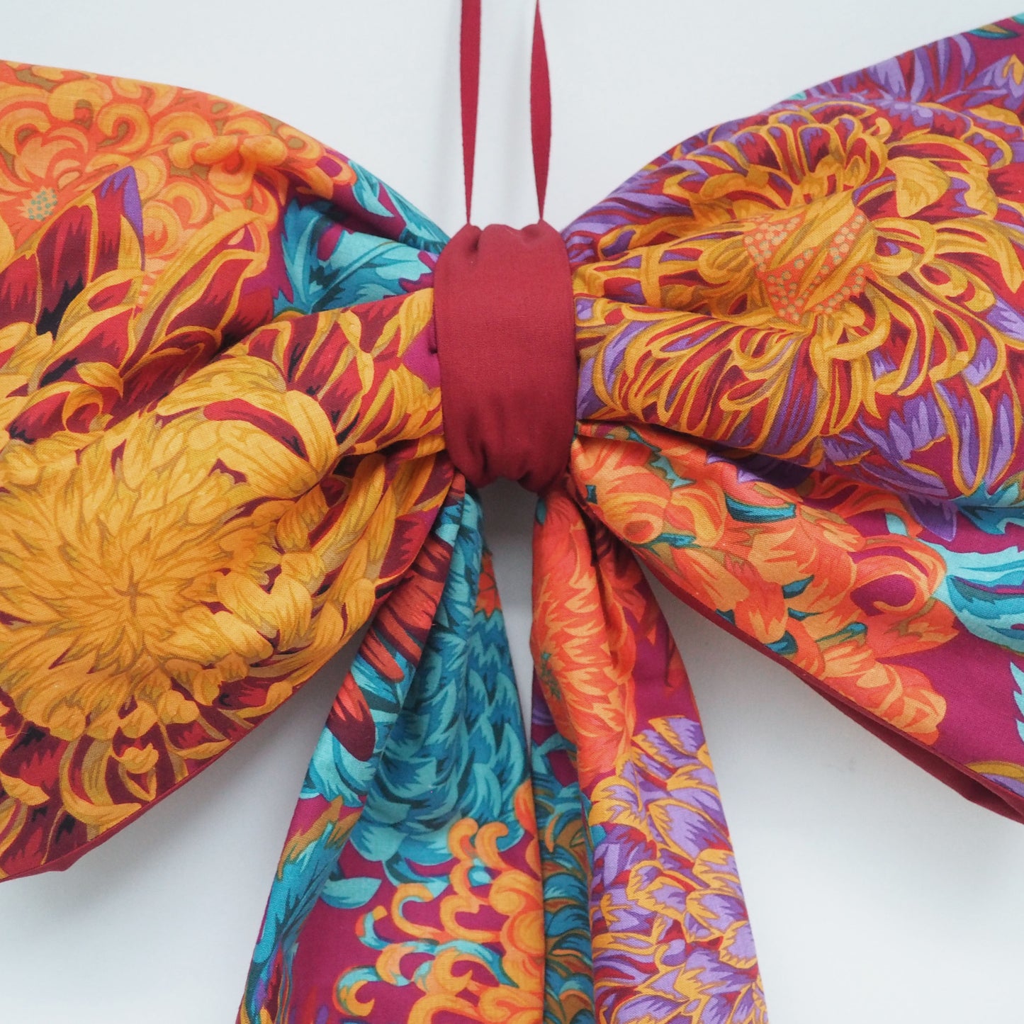 Handmade large padded decorative hanging bow - orange/purple floral