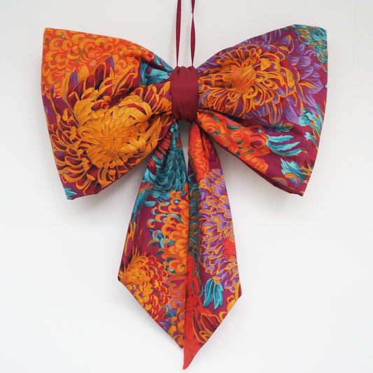 Handmade large padded decorative hanging bow - orange/purple floral